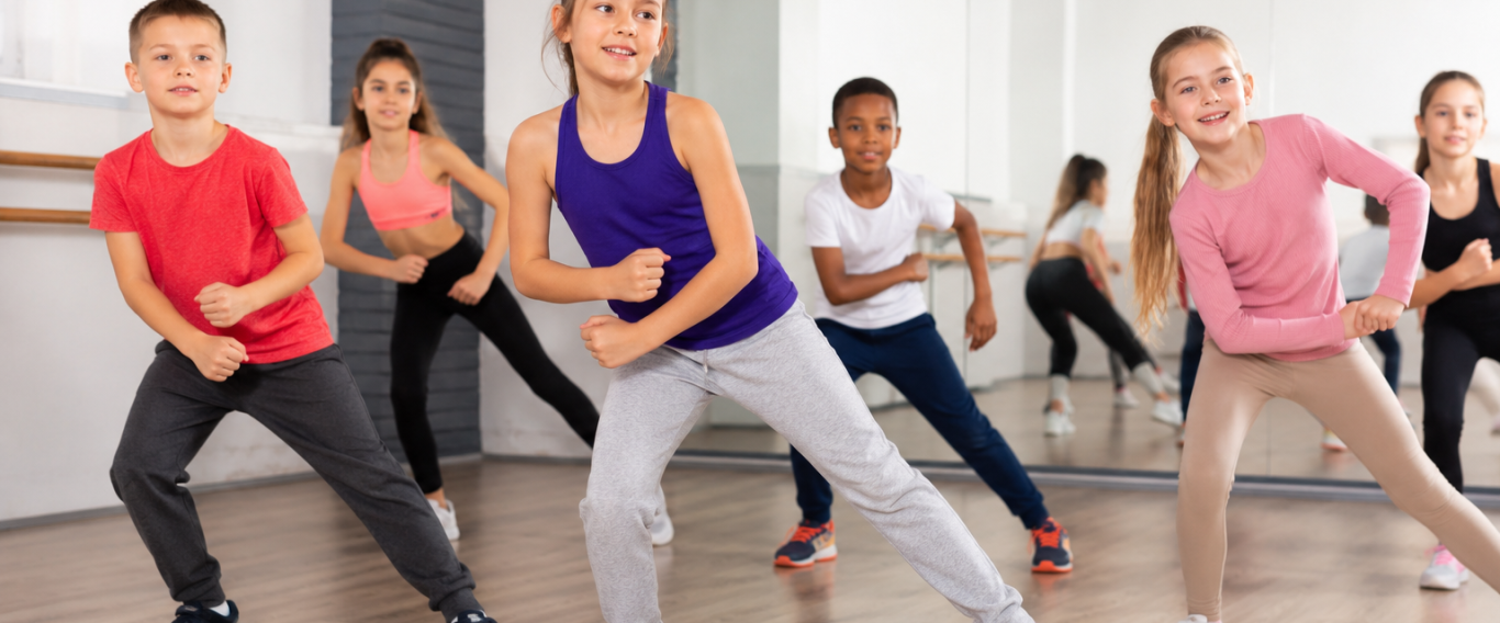 Des enfants dansent en groupe, affichant des mouvements dynamiques dans un studio.
